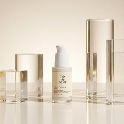 Skincare bottle with a gold cap on a reflective surface with a neutral background